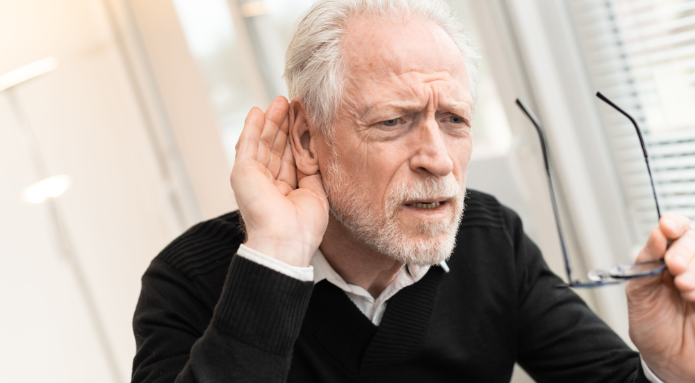 Older man having trouble hearing.
