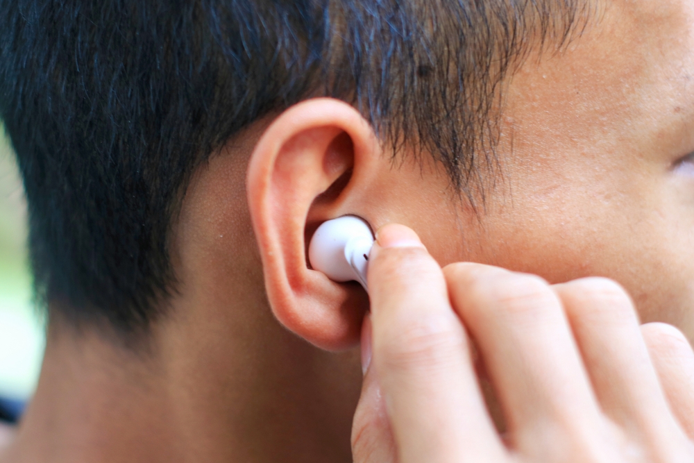 Person wearing earbuds.
